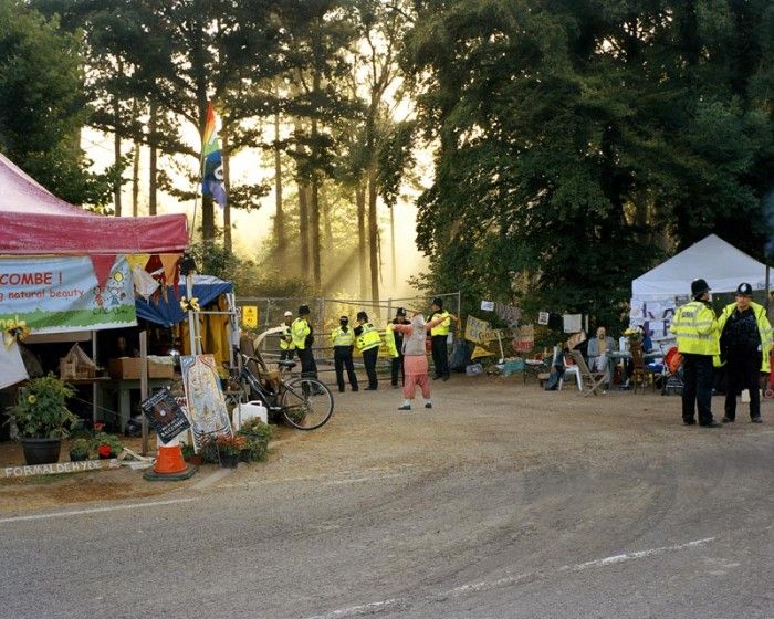 Balcombe, United Kingdom 2013 An anti-fracking protester in front of the gate of the Balcombe drilling site, West Sussex. From the 25th of July 2013, part of the population of Balcombe and activists from all over Britain gathered against unconventional gas explorations. They initially occupied the land on which the rig was supposed to be erected and then the road that leads towards Brighton. The so-called Great Gas Gala lasted 68 days: it did not prevent Cuadrilla from drilling, but it was a first and important moment of self-awareness for the British anti-fracking movement.