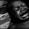Benjamin Rusnak - Boca Raton, FL -  Daily BathA baby cries after his daily bath in a river along the border of Haiti and the Dominican Republic.