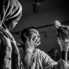 Rehana putting jel to his husband's burnt face who is a victim of political violence