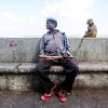 Neenad Arul - A Madari with red slippers on with his jamurah (Monkey) resting after a street performance