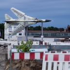 rik Tham - Retired Supersonic Birds: A discarded Russian MIG-23 fighter jet is set up for display in the midst of a temporary construction site in front of the museum for technology in Sinsheim, Germany