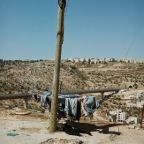 Steven Simon - Clotheshorse standing at a barely used road at Al-Walaja, a Palestinian village in the West Bank. Tunnel and bridge are part of the Bethlehem bypass of the Highway 60 leading from Beersheba to Nazareth. The Bridge was built illegally on Palestinian territory. The diggers being guarded by IDF soldiers. In the background lies Gilo. An Israeli settlement in south-western East Jerusalem