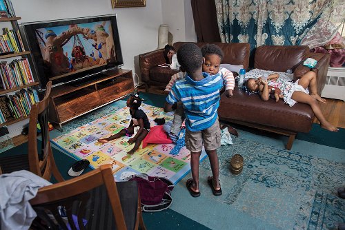 Karen Haberberg - Kids with rare conditions often require the assistance of young siblings. Alejandre, age 5, holds his baby brother, Mohammed. Mohammed and his sister Miriam, (who is watching television) are the first African Americans diagnosed with NGLY1